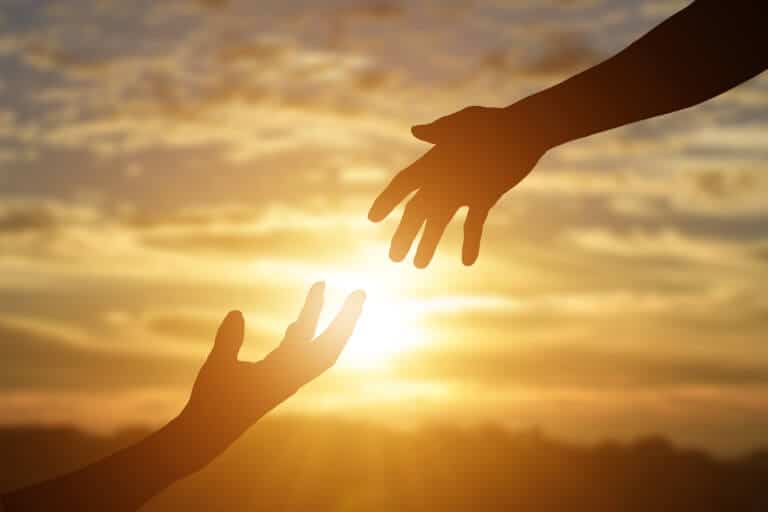 En hand som sträcker sig efter en annan hand för att hjälpa personen