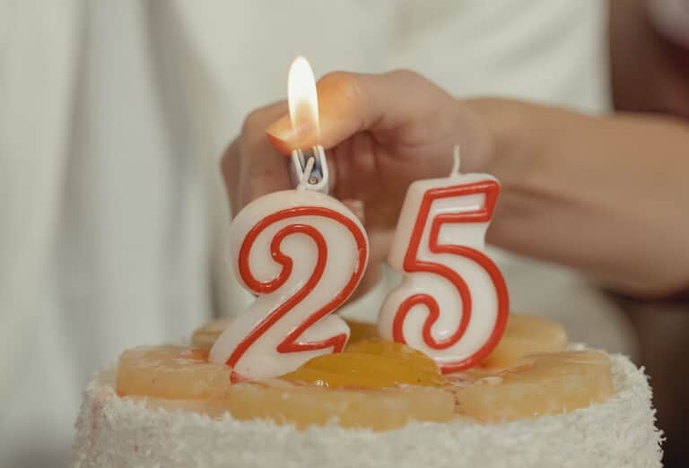 Kvinna som tänder ljusen på en födelsetårta i samband med någons 25-årsdag