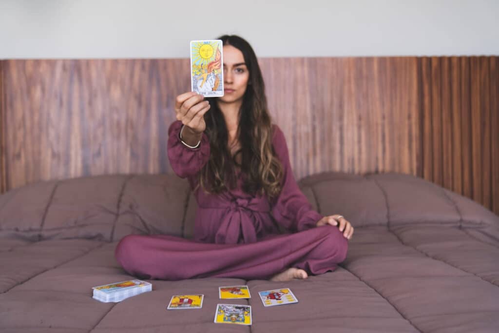 Kvinna som sitter i sängen och undrar hur mycket man kan lita på tarotkort