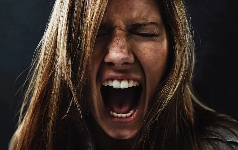 Kvinna som skriker rakt ut i frustration över en person