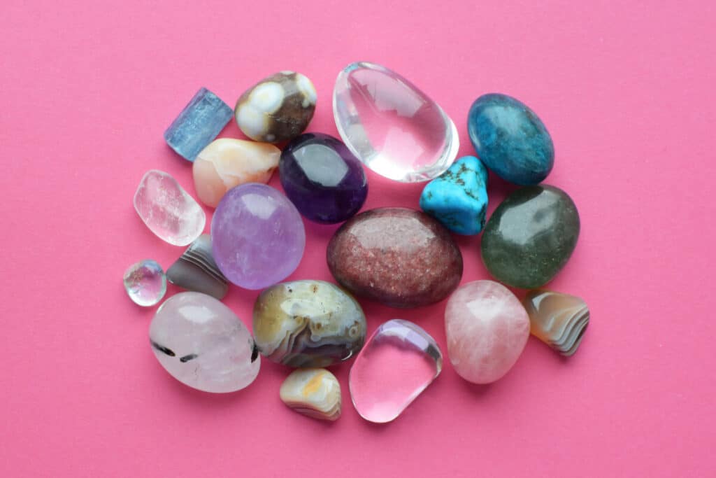 Flera olika kristaller för nybörjare mot en rosa bakgrund