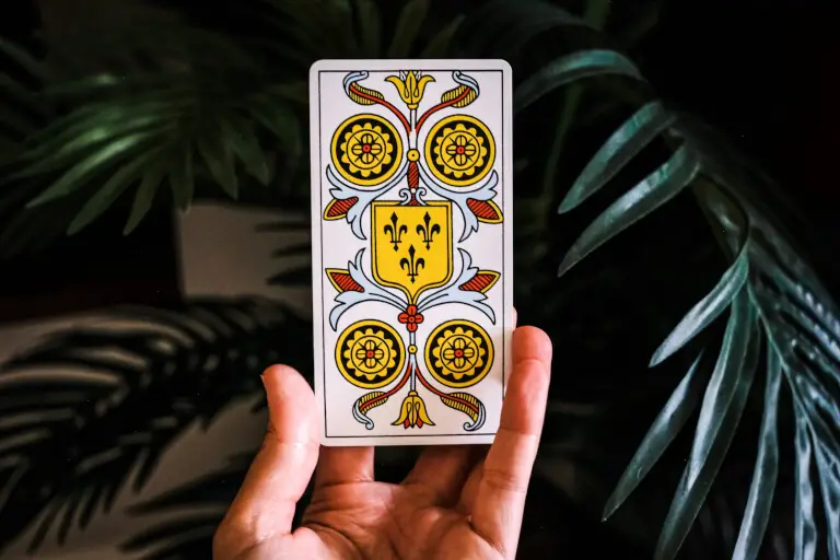 Hand som håller upp ett tarotkort